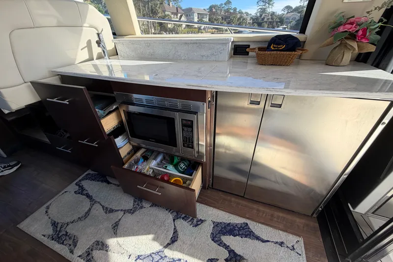 Slide: The Image of 2019 Regal 42 Grande Coupe yacht kitchen with microwave, cabinets, and countertop. - 47