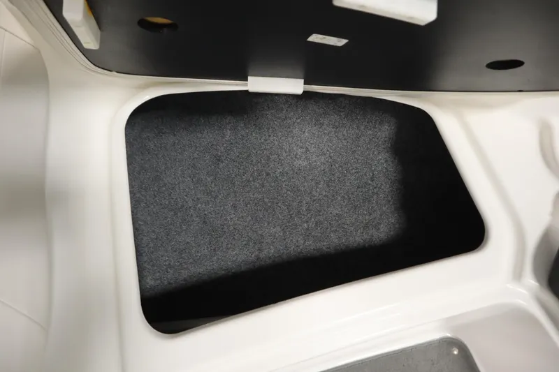 Slide: The Image of Storage compartment in a 2013 Yamaha Boats AR190, featuring a carpeted interior. - 12