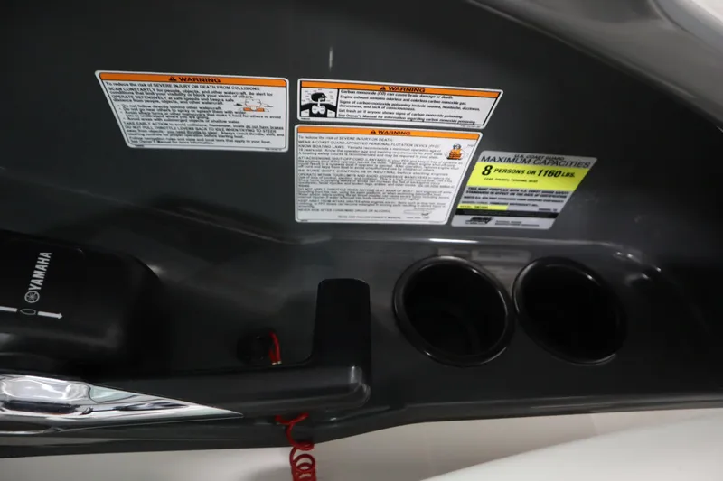 Slide: The Image of 2013 Yamaha AR190 boat dashboard with warning labels and cup holders. - 21