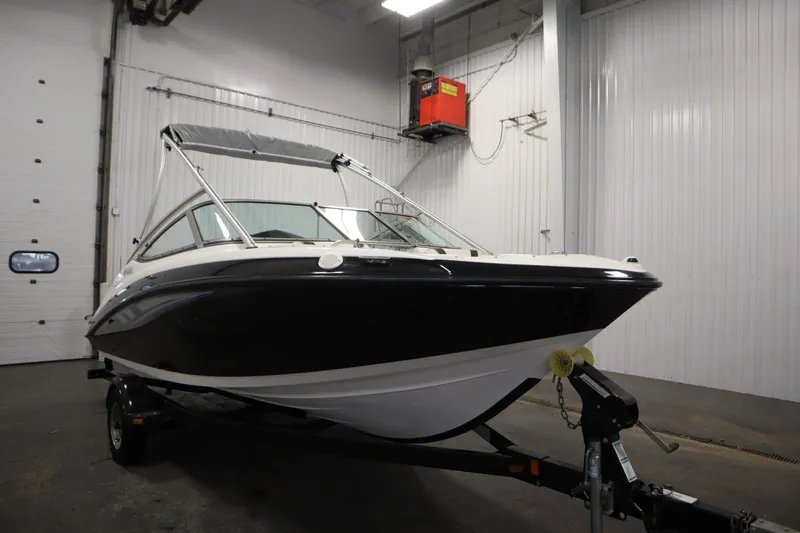 Slide: The Image of 2013 Yamaha Boats AR190 in indoor storage, black and white exterior, on a trailer. - 3