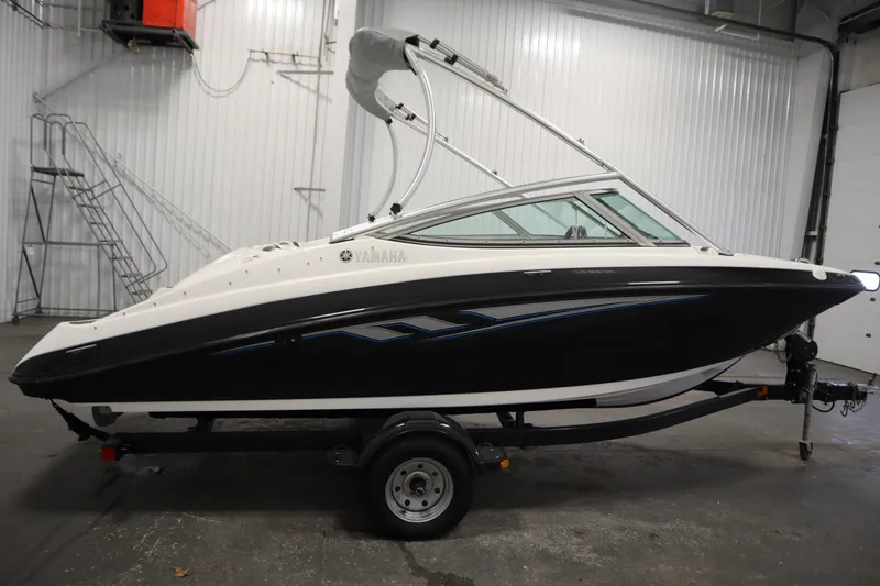 Slide: The Image of 2013 Yamaha Boats AR190 in a garage, black and white design, on a trailer. - 4