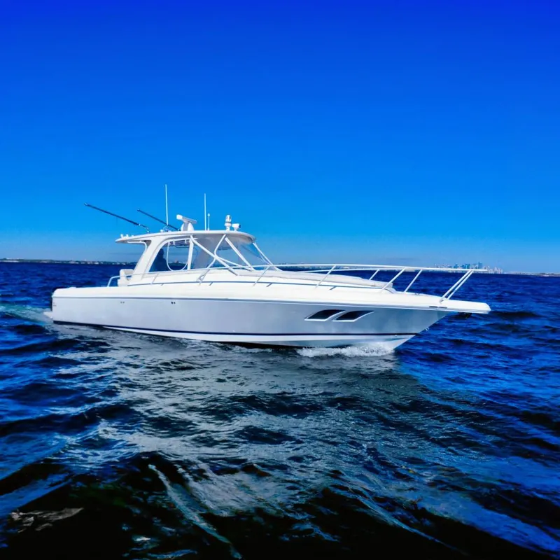 The Image of 2000 Intrepid 377 Walkaround boat cruising on open water under clear blue sky. - 0