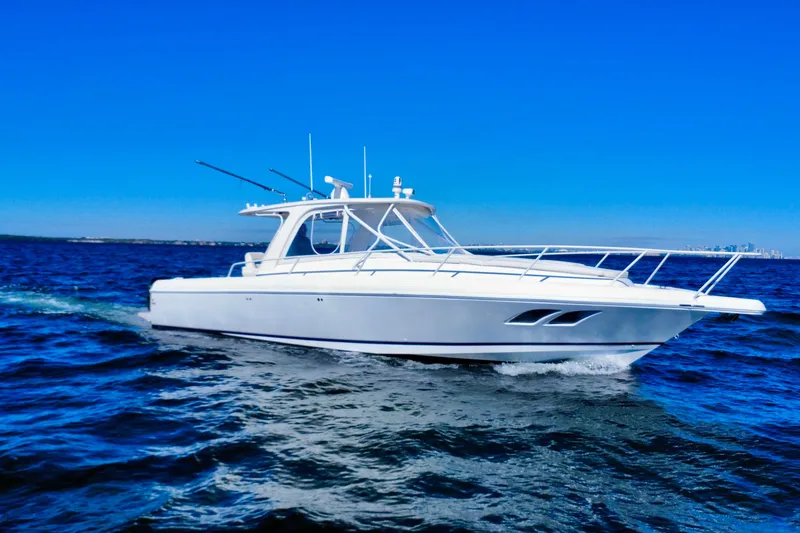 Slide: The Image of 2000 Intrepid 377 Walkaround boat cruising on open blue water under clear sky. - 1