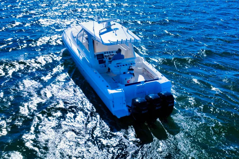 Slide: The Image of 2000 Intrepid 377 Walkaround boat on open water with triple Mercury engines. - 11