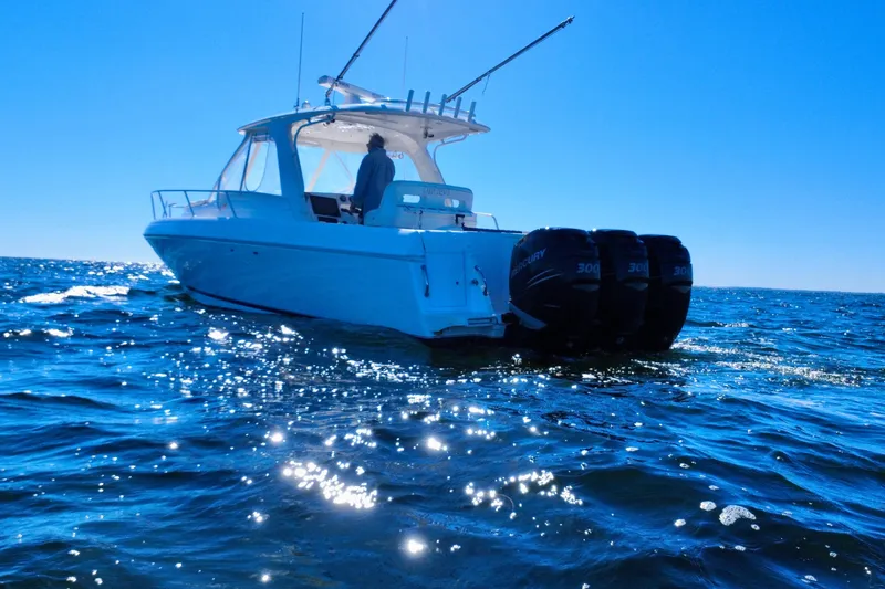 Slide: The Image of 2000 Intrepid 377 Walkaround boat cruising on open water with triple engines. - 12