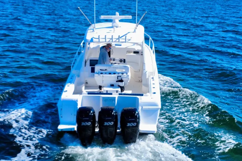 Slide: The Image of 2000 Intrepid 377 Walkaround boat cruising on open sea under clear blue sky. - 13