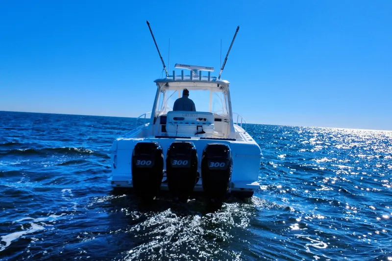 Slide: The Image of Triple outboard engines on a 2000 Intrepid 377 Walkaround boat in water. - 14