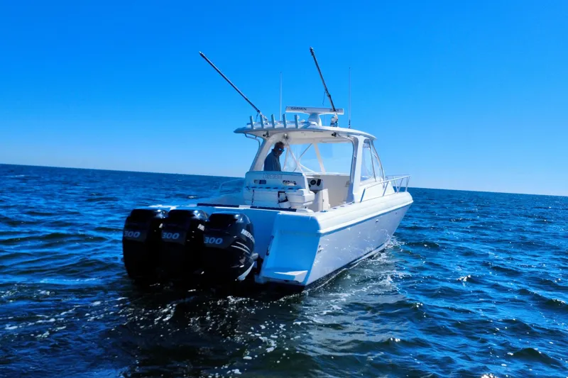 Slide: The Image of 2000 Intrepid 377 Walkaround boat cruising on open water under clear blue sky. - 17
