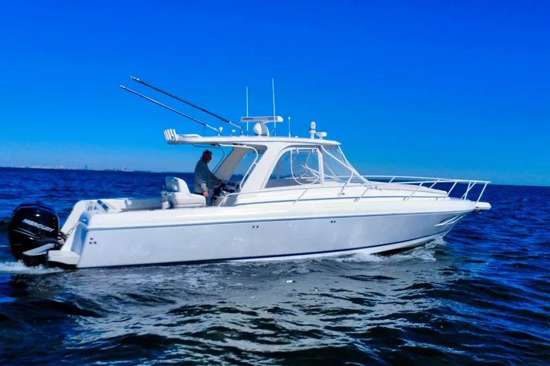 Slide: The Image of 2000 Intrepid 377 Walkaround boat cruising on open water, featuring triple Mercury engines. - 18