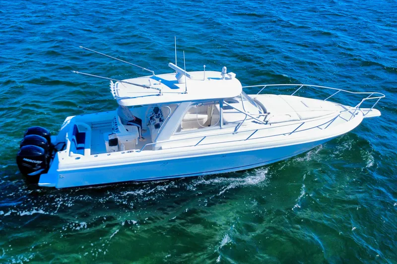 Slide: The Image of 2000 Intrepid 377 Walkaround boat on open water under clear blue sky. - 19