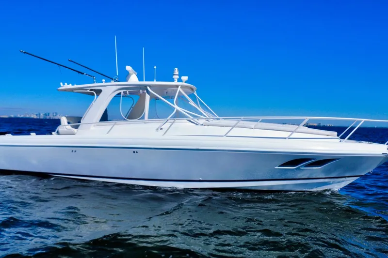 Slide: The Image of Triple Mercury outboard engines on a 2000 Intrepid 377 Walkaround boat, docked in clear water. - 22