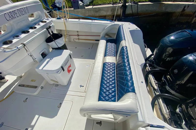 Slide: The Image of 2000 Intrepid 377 Walkaround boat with blue and white seating, docked under sunny skies. - 27