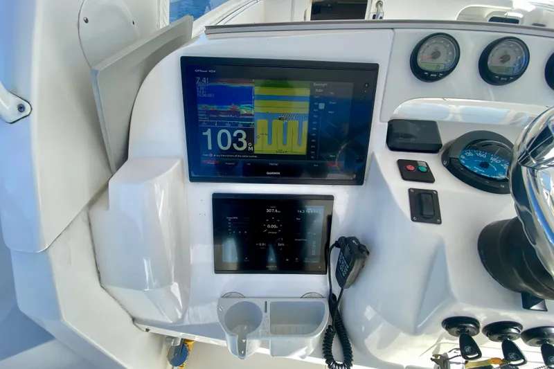 Slide: The Image of Control panel of a 2000 Intrepid 377 Walkaround boat with steering wheel and gauges. - 34