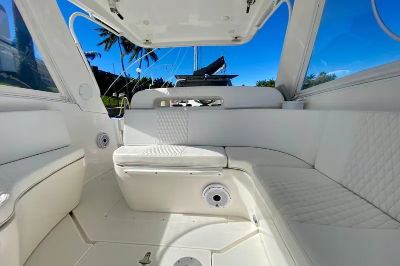 Slide: The Image of 2000 Intrepid 377 Walkaround boat interior with white seating and waterfront view. - 42