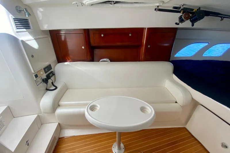 Slide: The Image of Interior of a 2000 Intrepid 377 Walkaround boat with white seating and wooden cabinets. - 48