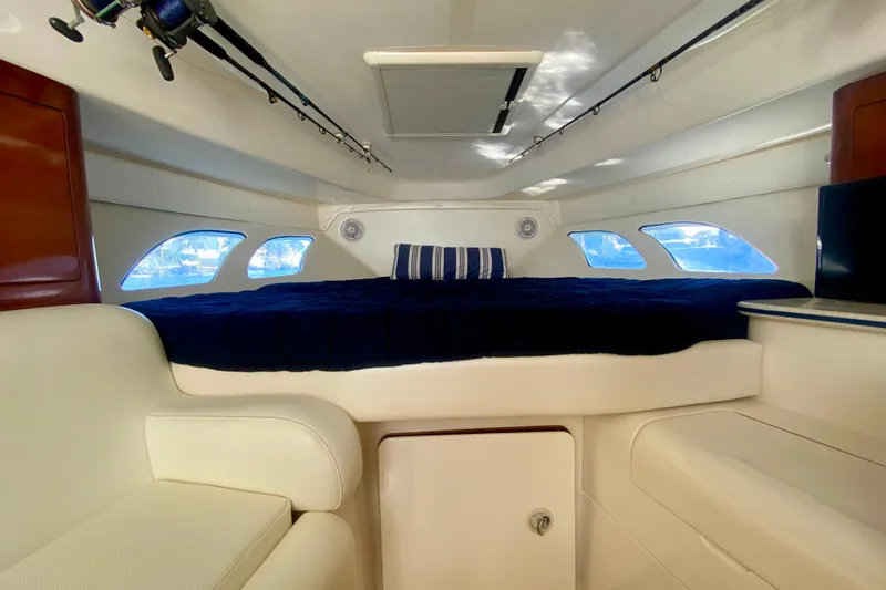 Slide: The Image of Interior of 2000 Intrepid 377 Walkaround boat with cozy bed and fishing rods. - 50