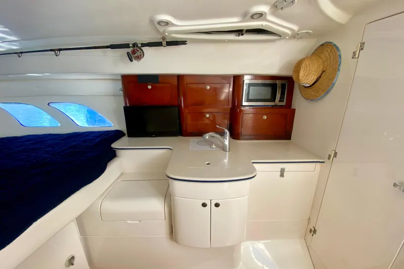 Slide: The Image of Interior of 2000 Intrepid 377 Walkaround boat with white seating and wooden accents. - 54