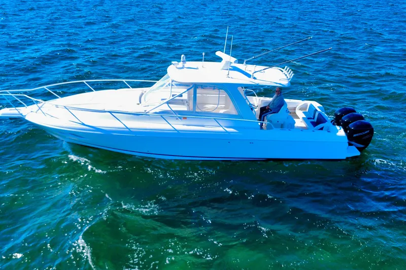 Slide: The Image of 2000 Intrepid 377 Walkaround boat cruising on open water under clear blue sky. - 8