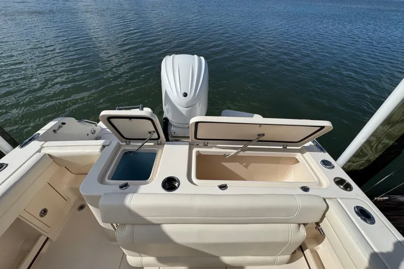 Slide: The Image of 2023 Grady-White Fisherman 236 boat with open storage compartments on calm water. - 12