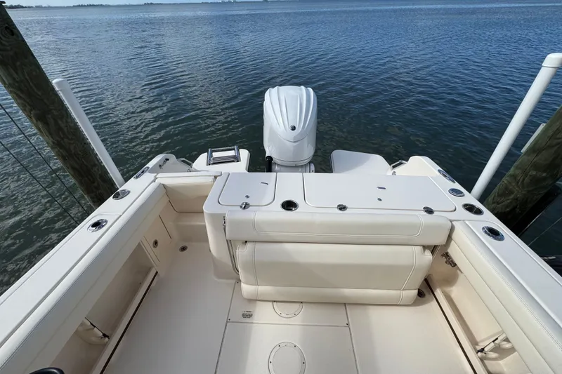 Slide: The Image of 2023 Grady-White Fisherman 236 boat interior with outboard motor, docked by calm water. - 15