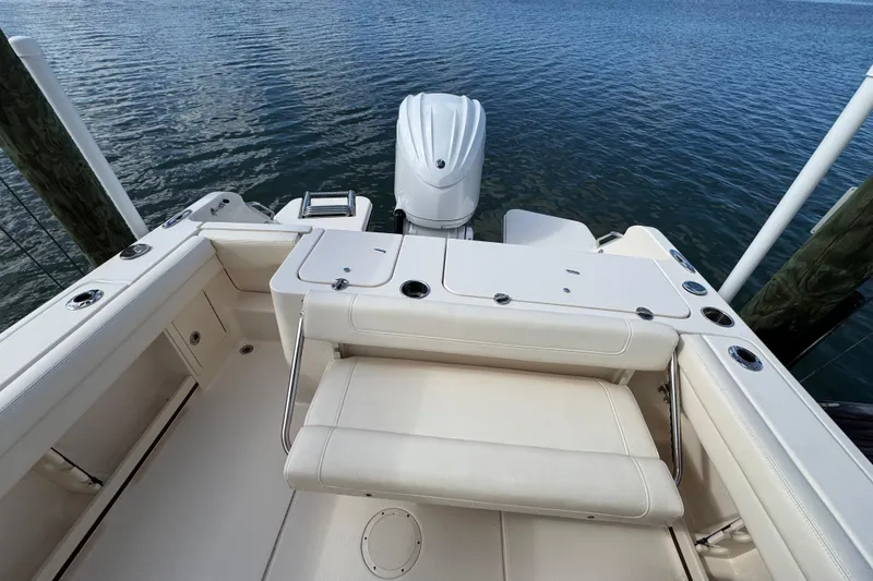 Slide: The Image of 2023 Grady-White Fisherman 236 boat interior with seating and motor, docked by water. - 16