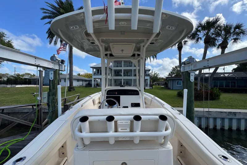 Slide: The Image of 2023 Grady-White Fisherman 236 boat docked, showcasing helm and rod holders. - 18