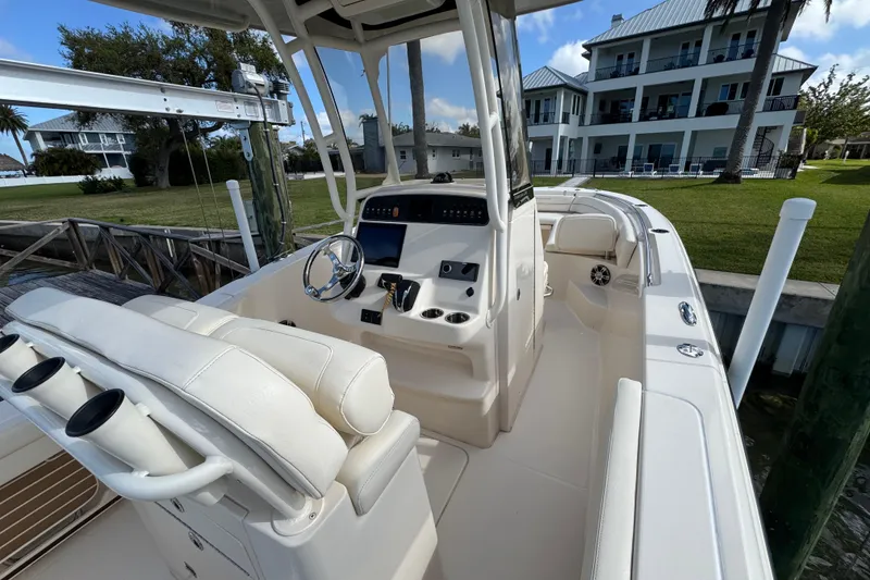 Slide: The Image of 2023 Grady-White Fisherman 236 boat interior with helm, docked near waterfront homes. - 23