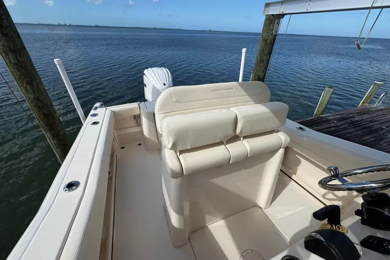 Slide: The Image of 2023 Grady-White Fisherman 236 boat interior with helm and seating, docked by the water. - 24