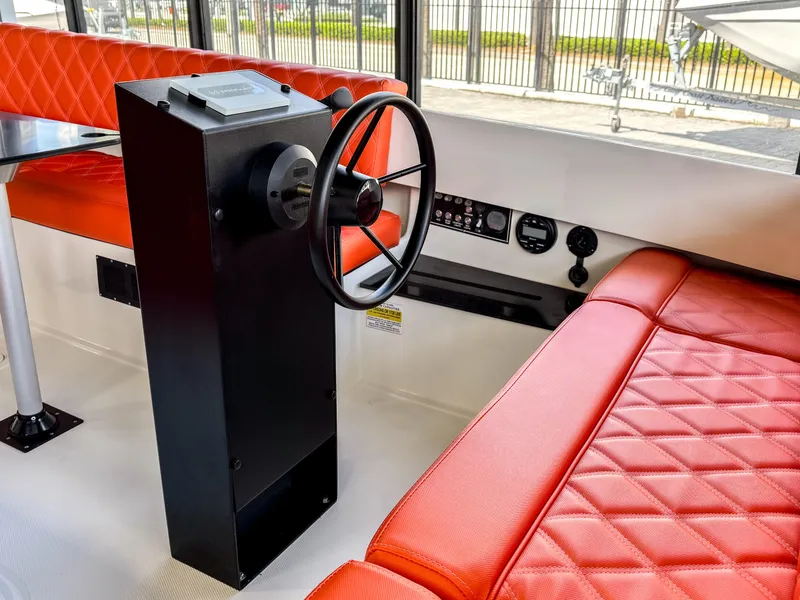 Slide: The Image of 2024 Vision Marine Technologies Fantail 217 interior with red quilted seating and steering console. - 4