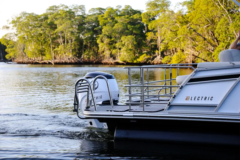 Slide: The Image of Electric Vision Marine Technologies V24 boat cruising on a serene river, surrounded by lush greenery. - 4