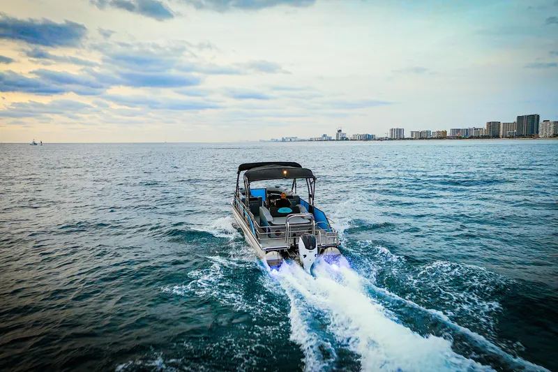 Slide: The Image of 2025 Vision Marine Technologies V30 boat cruising on open water near city skyline. - 7