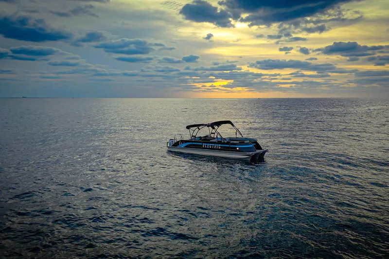 Slide: The Image of Electric Vision Marine Technologies V30 boat on serene ocean at sunset, 2025 model. - 9