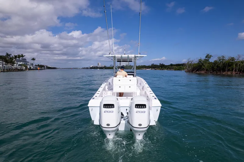 Slide: The Image of 2024 Bluewater 2550 boat cruising on a sunny day, twin engines visible. - 13