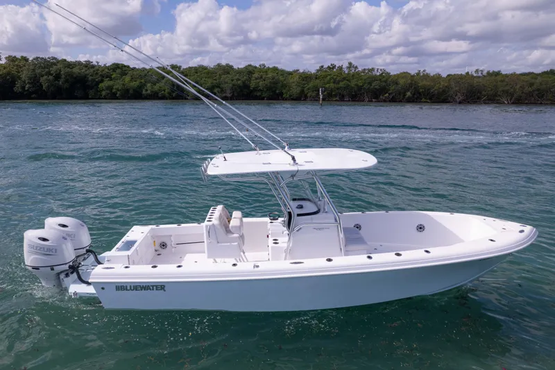 Slide: The Image of 2024 Bluewater 2550 boat on water, featuring dual Suzuki engines, under a cloudy sky. - 16