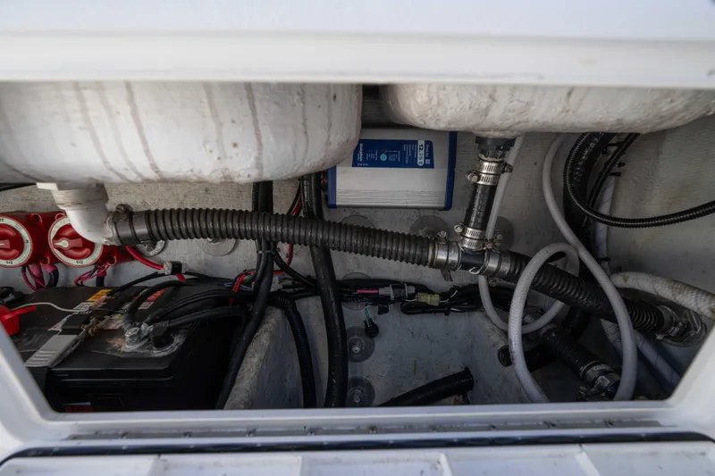 Slide: The Image of 2024 Bluewater 2550 boat interior showing battery, wiring, and plumbing components. - 18