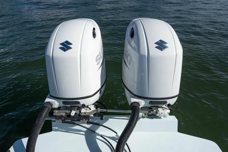 Slide: The Image of Twin Suzuki outboard motors on a 2024 Bluewater 2550 boat in water. - 21