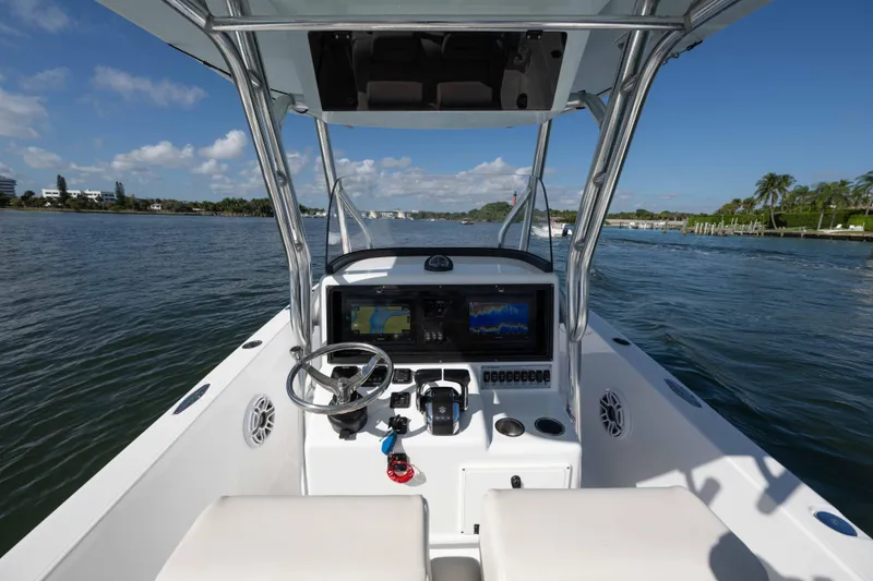 Slide: The Image of 2024 Bluewater 2550 boat console with navigation screens on a sunny day. - 26