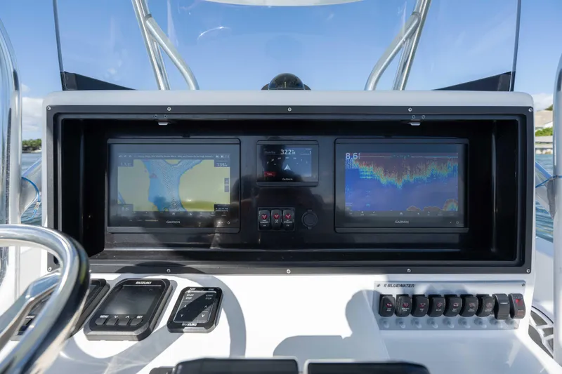 Slide: The Image of 2024 Bluewater 2550 boat dashboard with dual Garmin displays and control panel. - 27