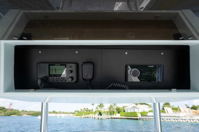 Slide: The Image of 2024 Bluewater 2550 boat console with Garmin and Fusion electronics, overlooking waterfront homes. - 28