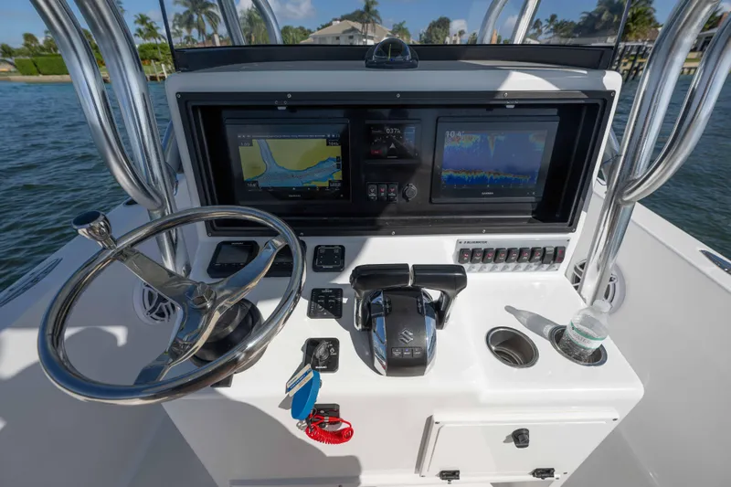Slide: The Image of 2024 Bluewater 2550 boat console with steering wheel, navigation screens, and controls. - 29
