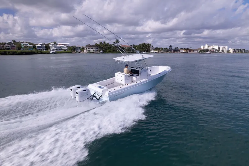Slide: The Image of 2024 Bluewater 2550 boat cruising on a calm waterway under a cloudy sky. - 3