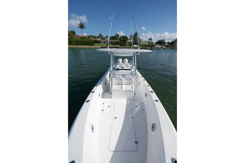 Slide: The Image of 2024 Bluewater 2550 boat on calm water, showcasing sleek design and spacious deck. - 33