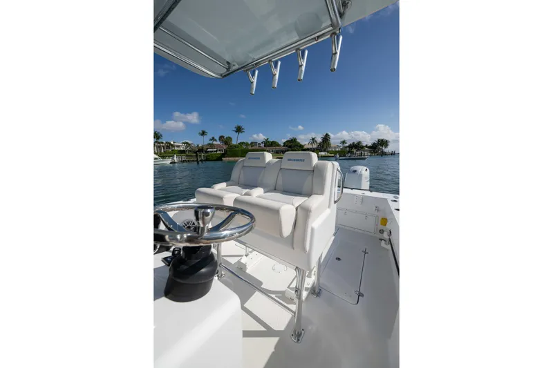 Slide: The Image of 2024 Bluewater 2550 boat interior with helm and seating, on a sunny day by the water. - 34