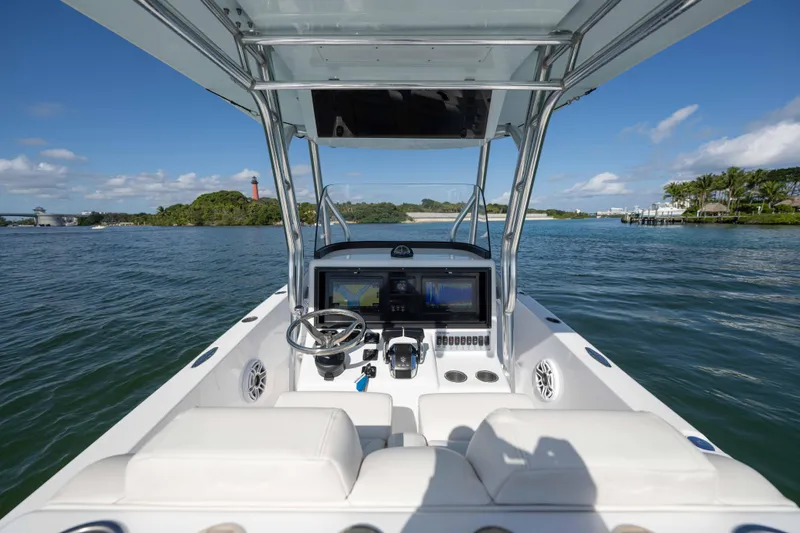 Slide: The Image of 2024 Bluewater 2550 boat cockpit with dual screens, steering wheel, and ocean view. - 36
