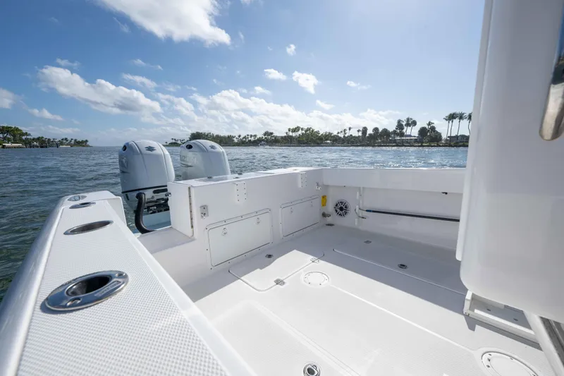 Slide: The Image of 2024 Bluewater 2550 boat interior with dual engines on a sunny day. - 56