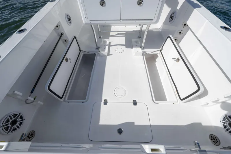 Slide: The Image of 2024 Bluewater 2550 boat deck with open storage compartments and speakers. - 59