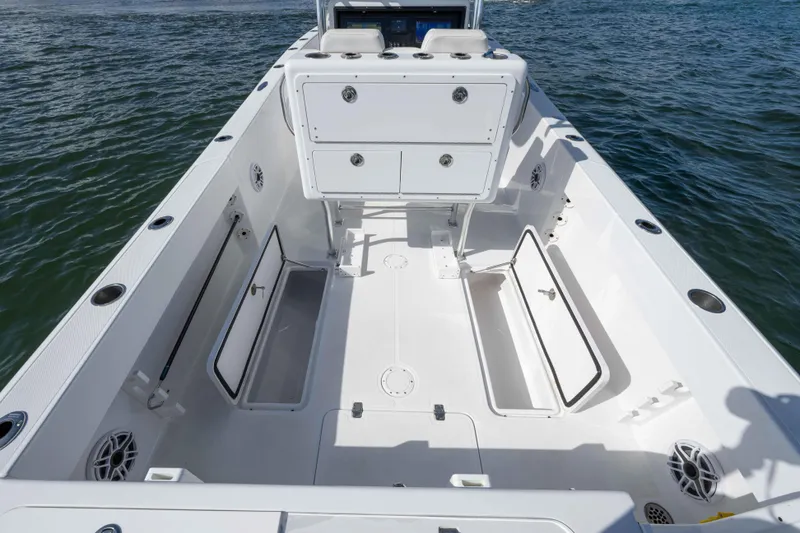Slide: The Image of 2024 Bluewater 2550 boat interior with open storage compartments on calm water. - 61