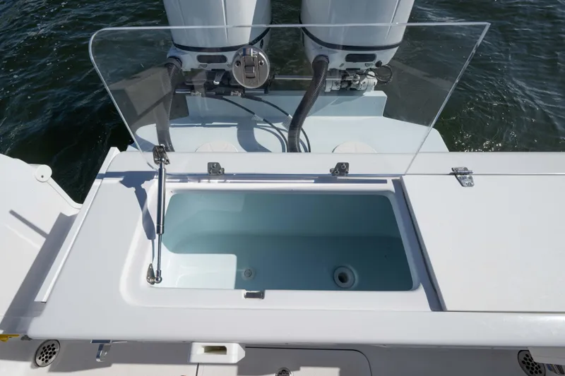 Slide: The Image of 2024 Bluewater 2550 boat with open livewell and dual outboard motors. - 63
