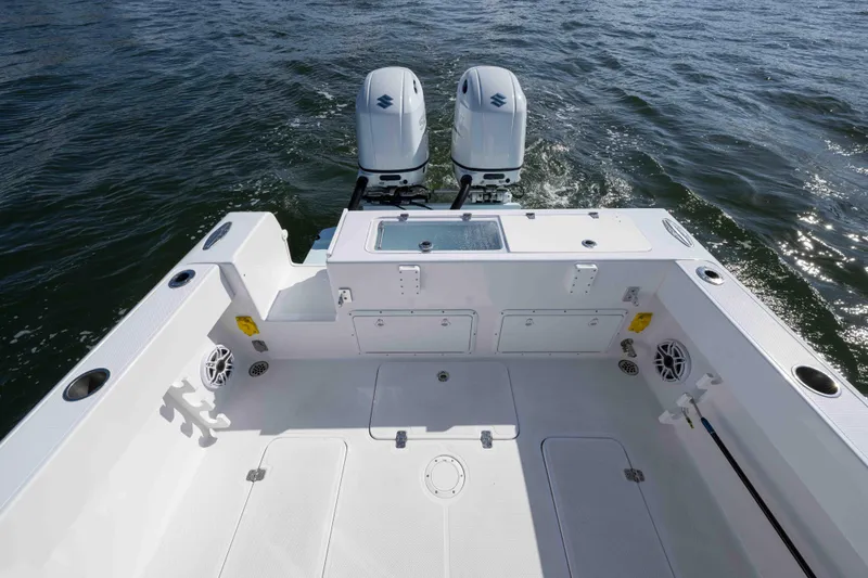 Slide: The Image of 2024 Bluewater 2550 boat deck with dual engines on open water. - 64