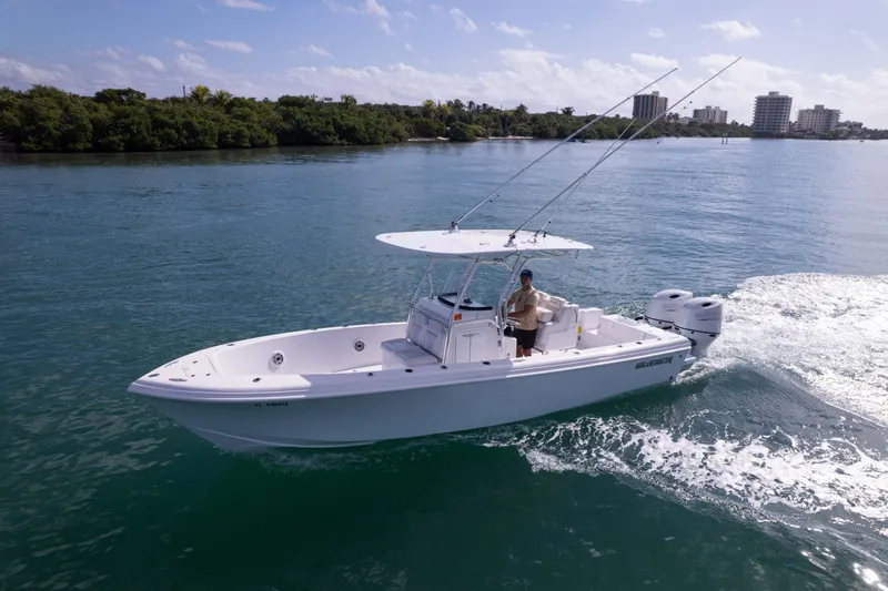 Slide: The Image of 2024 Bluewater 2550 boat cruising on a sunny day with lush shoreline in the background. - 66